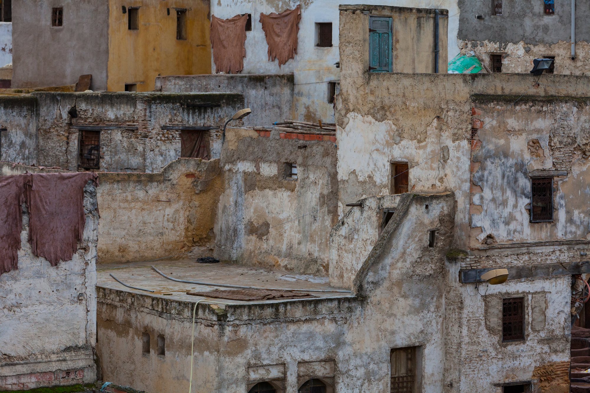 Salted hides hung to dry against a medina wall