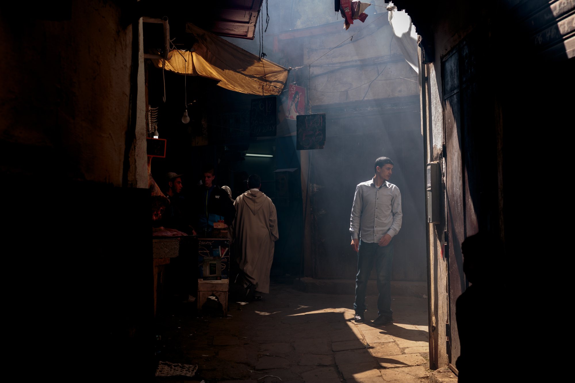 A shaft of light in the covered souk, and a man pausing in it