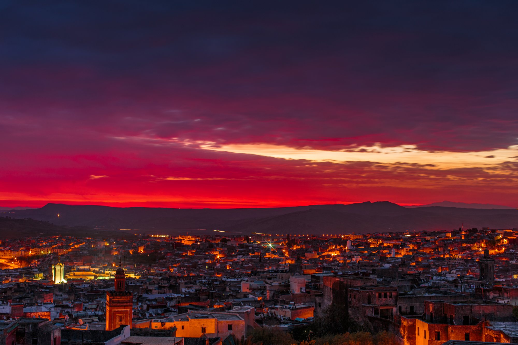 The medina at blue hour, minarets lit against a burning sky
