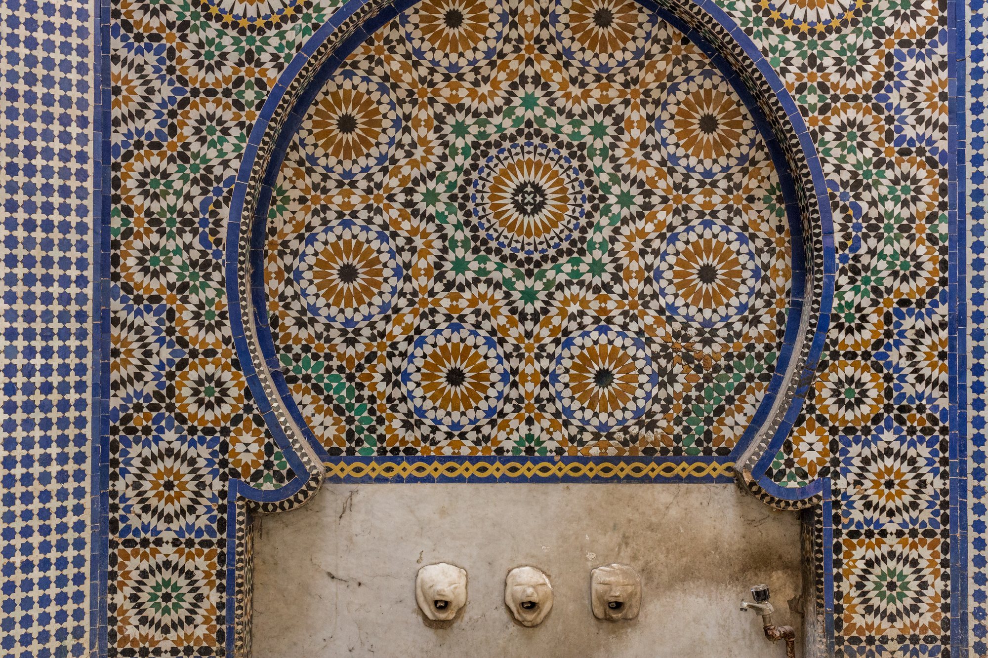 Zellige tilework and a lion-head fountain