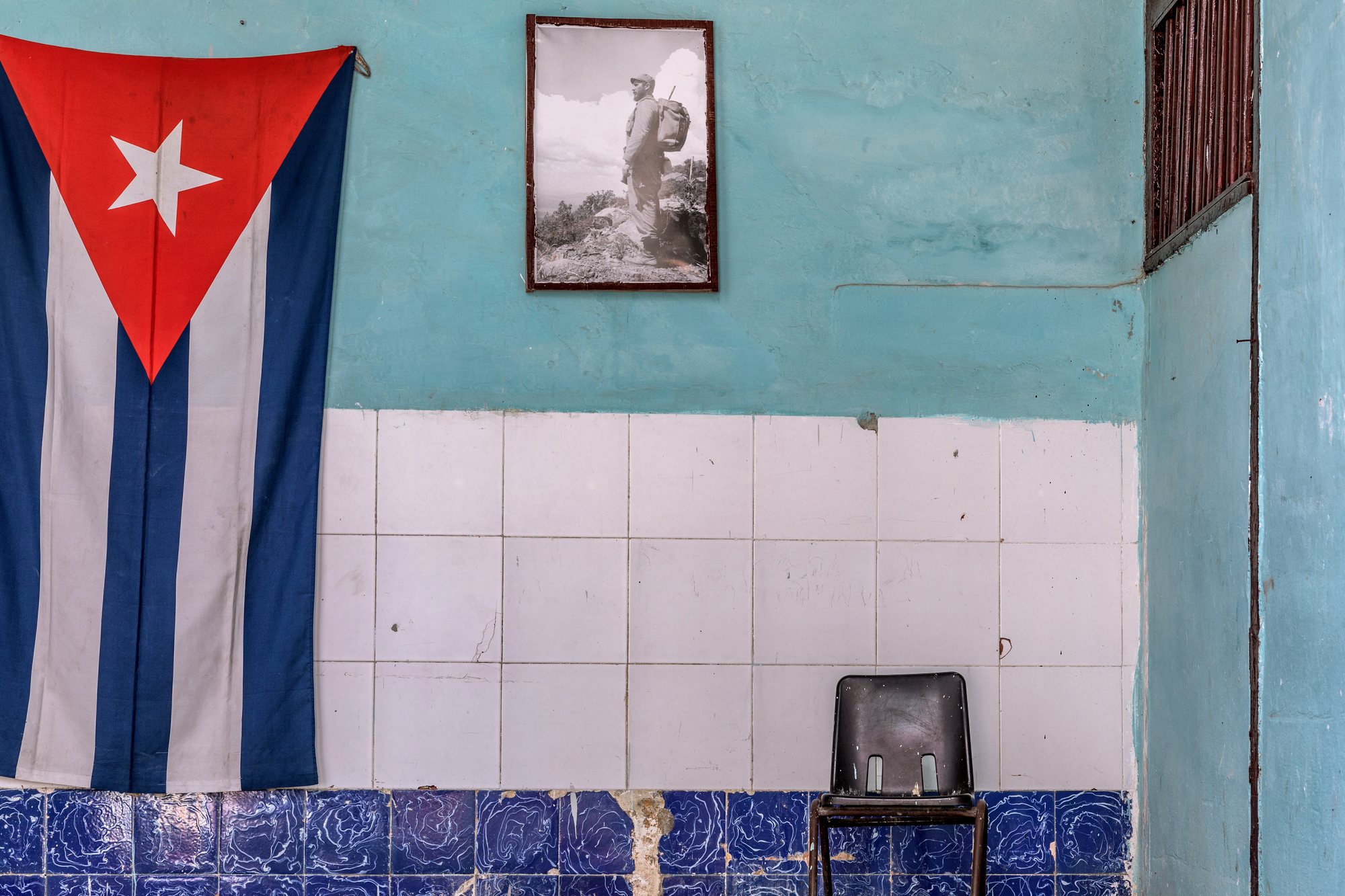 The Cuban flag and a portrait of Che on a turquoise wall